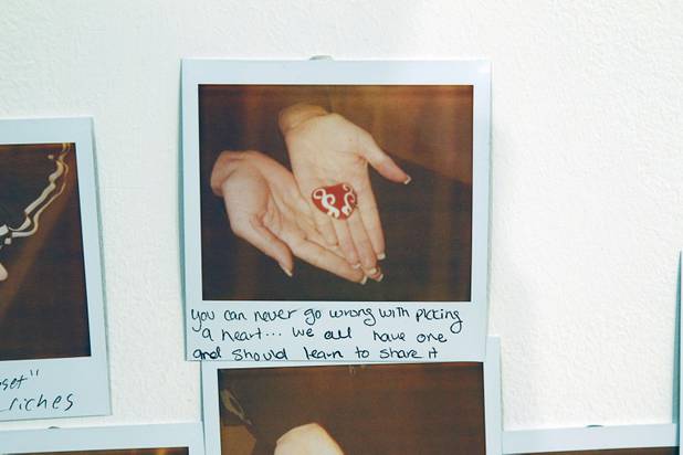 Polaroids are displayed on a wall at the Ellen Harvey Exhibit at the P3 Studio in the Cosmopolitan Monday, Dec. 17, 2012. "Exchange Your Luck" allows guests to swap ineffective lucky charms for new ones.  Two adjacent shelves in P3Studio will hold two sets of 77 different small bronze lucky charms by Ellen Harvey.  Each charm will be an edition of only two. One set of charms will stay in P3Studio for the duration of the residency, while the other set is available for guests to take provided they leave their own lucky charm in exchange. The object for which the charm is swapped will be photographed and its Polaroid installed on the wall.