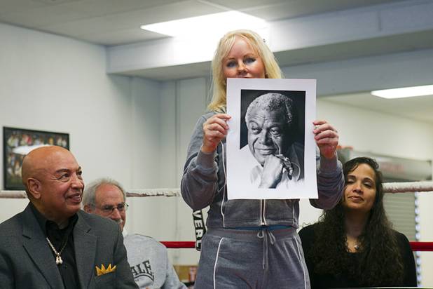 Eva Futch, widow of boxing trainer Eddie Futch, holds her husband's photo during a Nevada Boxing Hall of Fame (NVBHOF) news conference at the Richard Steele Boxing Club in North Las Vegas Wednesday, Dec. 19, 2012. Induction will take place in 2013. Seated are former referee Joe Cortez and Michelle Corrales, widow of boxer Diego "Chico" Corrales. Diego Corrales died in a motorcycle accident in 2007.