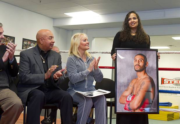 Michelle Corrales, widow of boxer Diego "Chico" Corrales holds a photo of her husband during a Nevada Boxing Hall of Fame (NVBHOF) news conference at the Richard Steele Boxing Club in North Las Vegas Wednesday, Dec. 19, 2012. Diego Corrales died in a motorcycle accident in 2007. At left is former boxing referee Joe Cortez and Eva Futch, widow of boxing trainer Eddie Futch. Induction will take place in 2013.