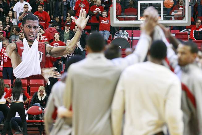 While the UNLV team huddles before their game against UNI, the student section holds up a giant cut out of Mike Moser with his arm in a sling Wednesday, Dec. 19, 2012 at the Thomas & Mack. UNLV won 73-59 to push their record to 10-1.