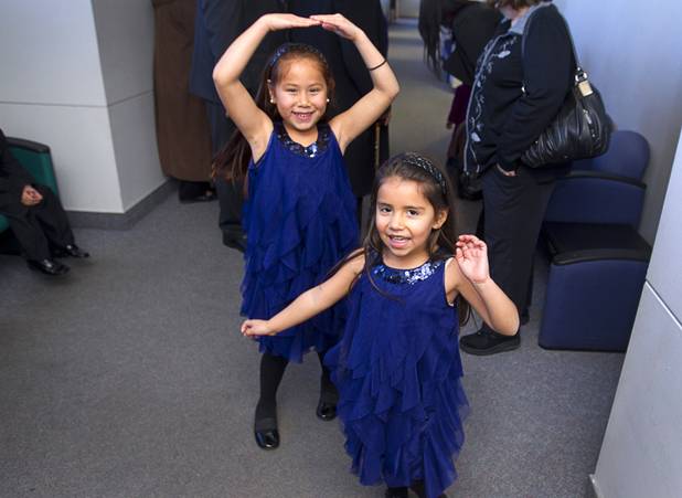 Sierra, 6, left, and Daisy, 5, dance in a walkway at family court Thursday, Dec. 20, 2012. The family officially adopted four more children, including Sierra, for a total of eleven children.