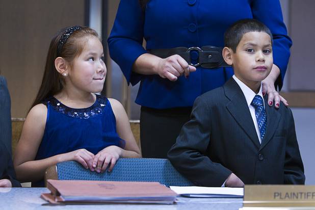 Sierra, 6, and Timmy, 5, stand by their mother as they are officially adopted at family court Thursday, Dec. 20, 2012. The family officially adopted four more children for a total of eleven children.