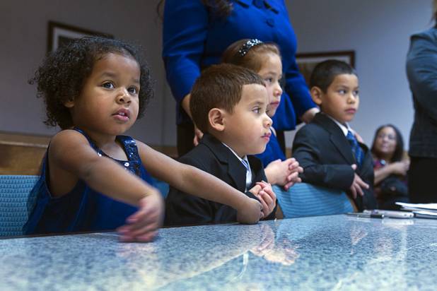 Maciel children, from left, Julie, 3, Joey, 5, Sierra, 6, and Timmy, 7, are officially adopted during an adoption proceeding at family court Thursday, Dec. 20, 2012. The family officially adopted four more children for a total of eleven children.