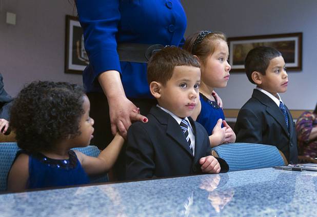 Maciel children, from left, Julie, 3, Joey, 5, Sierra, 6, and Timmy, 7, are officially adopted during an adoption proceeding at family court Thursday, Dec. 20, 2012. The family officially adopted four more children for a total of eleven children.