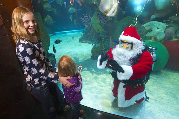 Santa waves to children from the Silverton's 117,000-gallon aquarium Sunday, Dec. 23, 2012. Santa took Christmas present requests from children using an underwater microphone. 