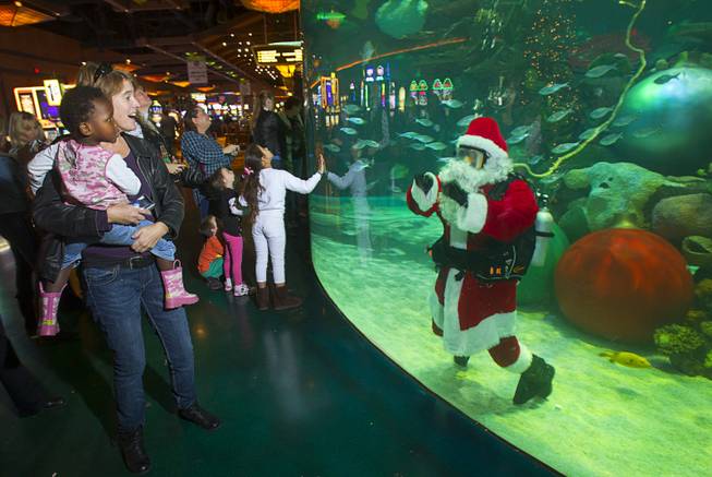 Jennifer Caldwell, left, and her daughter Mari, 3, check out the underwater Santa at the Silverton's 117,000-gallon aquarium Sunday, Dec. 23, 2012. Santa took Christmas present requests from children using an underwater microphone.