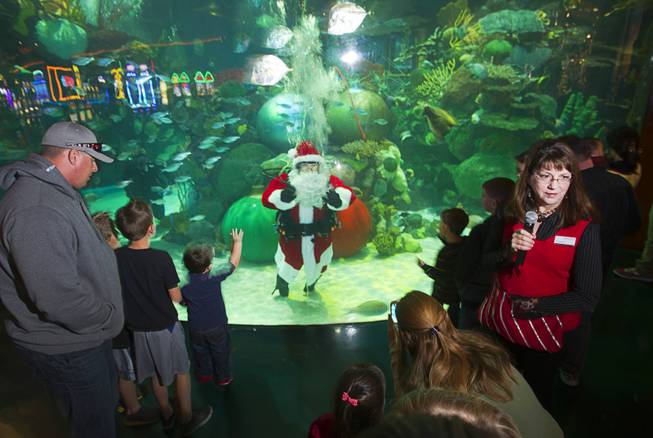 Santa waves to children from the Silverton's 117,000-gallon aquarium Sunday, Dec. 23, 2012. Santa took Christmas present requests from children using an underwater microphone.