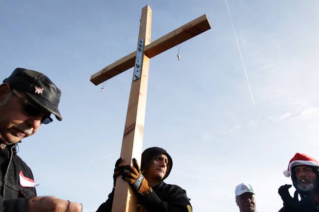 Bernie Ibarra, center, holds a cross made by Mike Yarusso, ...