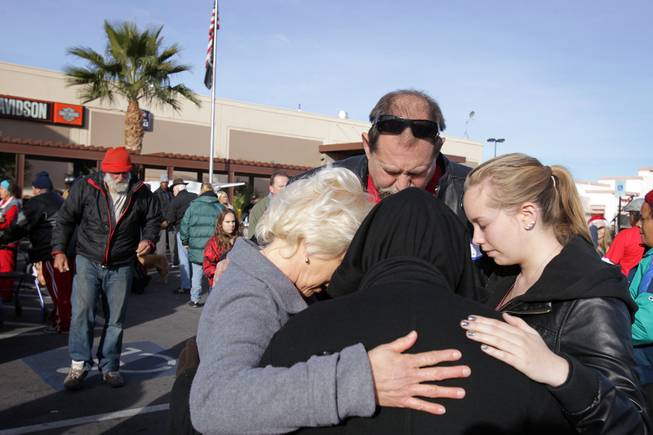 Shelly Alfaro, from left, prays with her husband David Alfaro and daughter Chelsea Alfaro, 18, during a Christmas Day event to feed and clothe the homeless and needy organized by the nonprofit organization Broken Chains in Las Vegas on Tuesday, December 25, 2012.