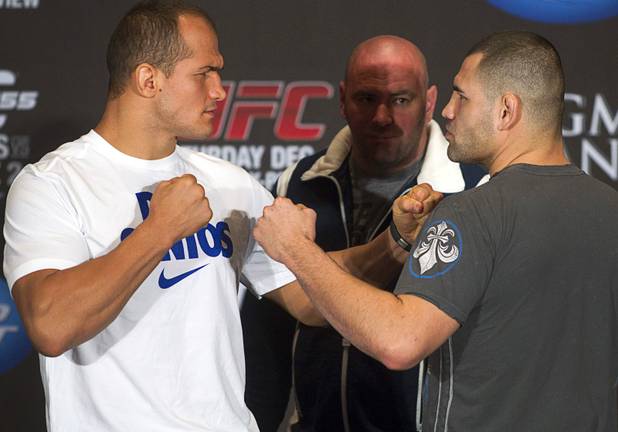 UFC heavyweight champion Junior Dos Santos, left, of Brazil and Cain Velasquez of San Jose, Calif. pose during a news conference at the MGM Grand Thursday, Dec. 27, 2012. UFC president Dana White looks on at center. Dos Santos will defend the title against Velasquez at UFC155 at the MGM Grand Garden Arena Saturday .