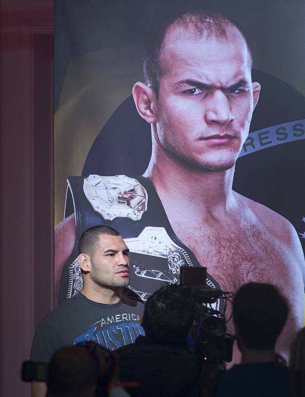 Former UFC heavyweight champion Cain Velasquez of San Jose, Calif. walks by a banner with the image of Junior Dos Santos of Brazil during a news conference at the MGM Grand Thursday, Dec. 27, 2012. Velasquez will try and reclaim his title from Dos Santos during UFC155 at the MGM Grand Garden Arena Saturday.