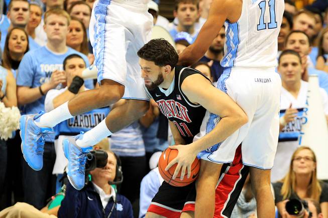 UNLV forward Carlos Lopez-Sosa is fouled by North Carolina forwards J.P. Tokoto, left, and Brice Johnson during their game Saturday, Dec. 29, 2012 at the Dean Smith Center in Chapel Hill, N.C.