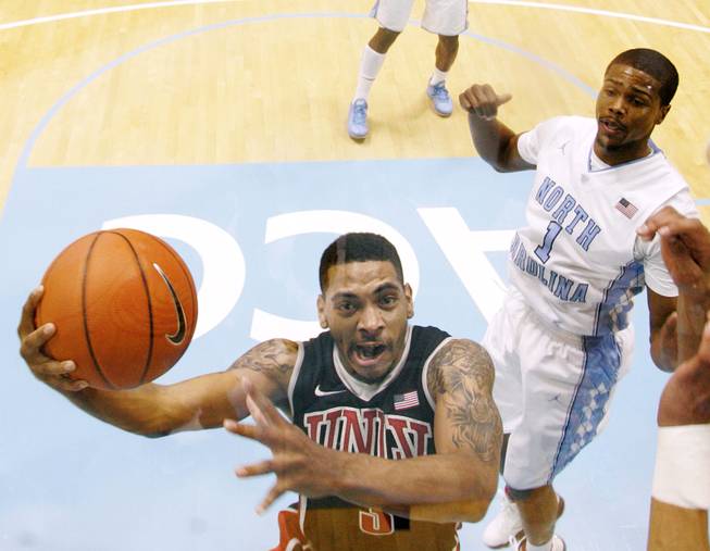 UNLV guard Anthony Marshall drives to the basket past North Carolina guard Dexter Strickland during their game Saturday, Dec. 29, 2012 at the Dean Smith Center in Chapel Hill, N.C. North Carolina won the game 79-73.