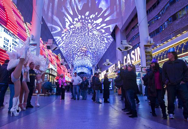 Showgirls pose with guests during the New Years Eve party at the Fremont Street Experience Monday, Dec. 31, 2012.