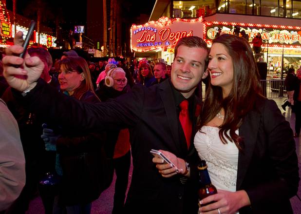 Newlyweds Rick and Trista Fox of Milwaukee, Wis. take a self portrait during the New Years Eve party at the Fremont Street Experience Monday, Dec. 31, 2012.