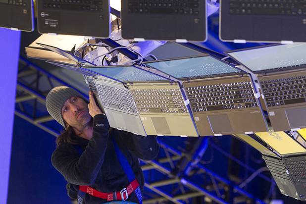 Rigger Matt Gerbracht arranges a display of Ultrabooks powered with Intel processors as workers prepare for the International CES show at the Las Vegas Convention Center in Las Vegas, Nevada January 4, 2013. The annual CES electronics technology trade show is expected to cover 1.85 million square feet of exhibition space and attract 150,000 attendees. The show begins January 8.