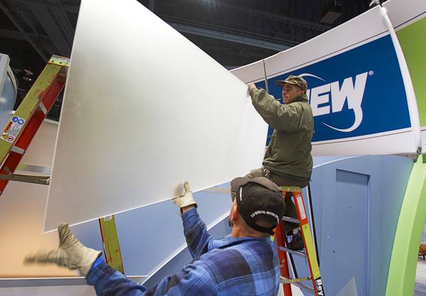 Danny Bodon, left, and Douglas Schlageter work on the National Extended Warranties booth as they set up for the  International CES show at the Las Vegas Convention Center in Las Vegas, Nevada January 4, 2013. The annual CES electronics technology trade show is expected to cover 1.85 million square feet of exhibition space and attract 150,000 attendees. The show begins January 8.