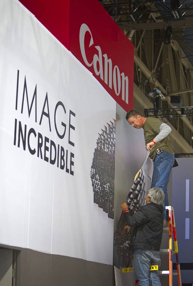 Workers set a booth for Canon cameras for the International CES at the Las Vegas Convention Center in Las Vegas, Nevada January 5, 2013. The annual CES electronics technology trade show is expected to cover 1.85 million square feet of exhibition space and attract 150,000 attendees. The show begins January 8.