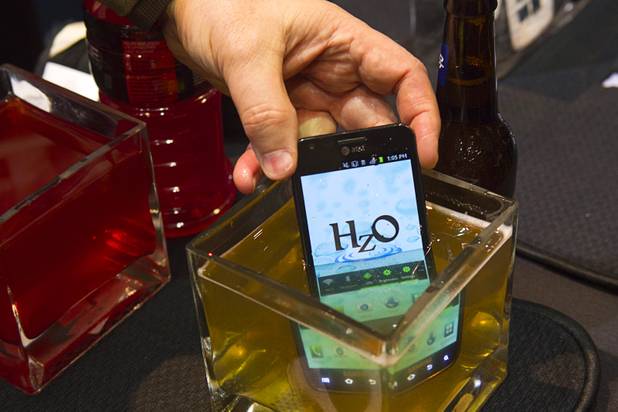 A smart phone with HzO Waterblock technology is dipped in beer at the opening press event of the 2013 International CES at the Mandalay Bay Convention Center Sunday, January 6, 2013. The system is currently marketed at manufacturers but may have  future consumer applications, a representative said.