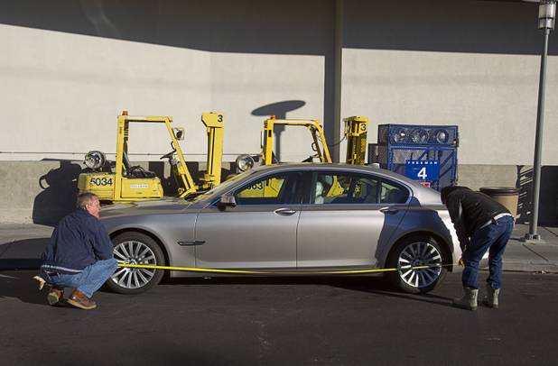 Reliable Crane employees make measurements before lifting a 2008 BMW 740i, equipped with a new Harman electronic system, into the Studio at the Palms Sunday, Jan. 6, 2013. The concept vehicle is integrated with new technology which will be unveiled Tuesday, a representative said. Harman is using the recording studio as a showroom to show off the system.