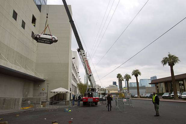 Reliable Crane employees watch from third floor cargo bay as a 2008 BMW 740i equipped with a new Harman electronic system is lifted into the Studio at the Palms Sunday, Jan. 6, 2013. The concept vehicle is integrated with new technology which will be unveiled Tuesday, a representative said. Harman is using the recording studio as a showroom to show off the system.