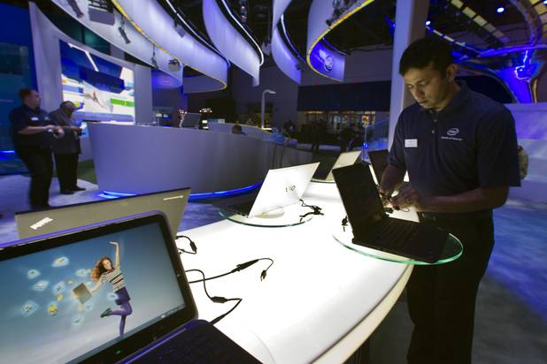 Raman Chari prepares a display of convertible Ultrabooks at the Intel booth prior to the opening of the 2013 International CES in the Las Vegas Convention Center Tuesday, Jan. 8, 2013. STEVE MARCUS