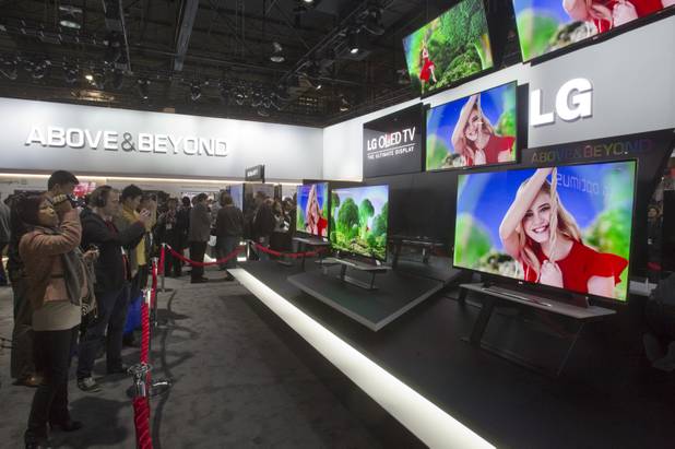Show-goers look per a display of 55-inch OLED televisions in the LG Electronics booth during the first day of the 2013 International CES in the Las Vegas Convention Center Tuesday, Jan. 8, 2013. The sets are the largest, lightest and thinnest OLED 3D TVs in production, a representative said. The televisions are expected to begin shipping in March. STEVE MARCUS