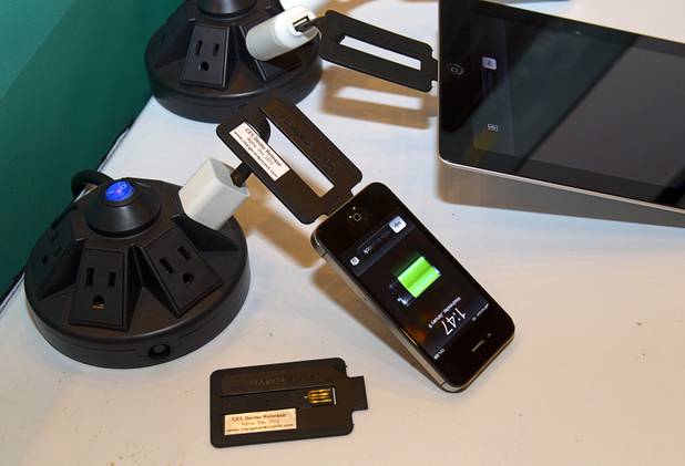 Devices are charged using a ChargeCard during the 2013 International CES Wednesday, January 9, 2013. The $25.00 flat, USB charging cable for iPhone 4 and Android devices is only slightly thicker than a credit card and is made to fit into a wallet. The cards are expected to be available in 3-5 weeks, said company CEO Noah Dentzel.