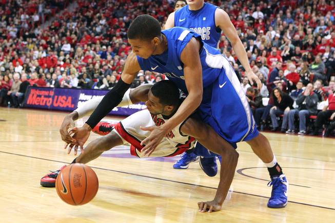 UNLV forward Mike Moser and Air Force guard Tre' Coffins hit the floor while chasing a loose ball during their game Saturday, Jan. 12, 2013 at the Thomas & Mack. UNLV won in overtime, 76-71.