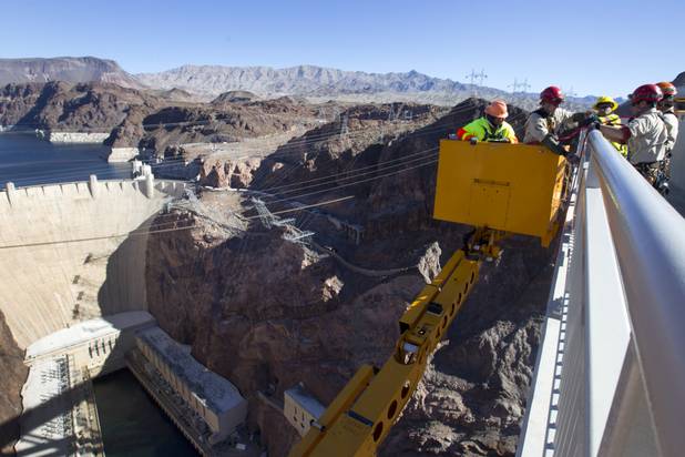 Myron Marr, a Nevada Department of Transportation bucket operator, left, and Matt Bialowas, a Stantec engineer/inspector, come up to a walkway during a safety inspection of the Mike O'Callaghan-Pat Tillman Memorial Bridge Wednesday, January 16, 2013.