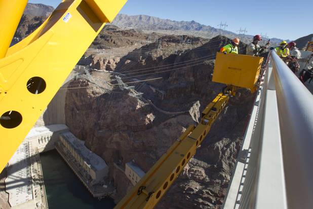 Myron Marr, a Nevada Department of Transportation bucket operator, left, and Matt Bialowas, a Stantec engineer/inspector, come up to a walkway during a safety inspection of the Mike O'Callaghan-Pat Tillman Memorial Bridge, Wednesday January 16, 2013.