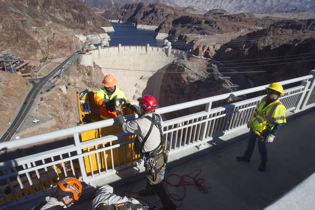 Myron Marr, a Nevada Department of Transportation bucket operator, left, unloads gear from a bucket during a safety inspection of the Mike O'CallaghanPat Tillman Memorial Bridge Wednesday, January 16, 2013.
