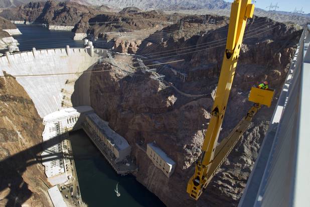 Myron Marr, a Nevada Department of Transportation bucket operator, lowers himself under the Mike O'Callaghan-Pat Tillman Memorial Bridge during a safety inspection Wednesday, January 16, 2013.