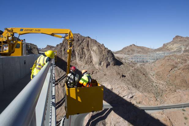 Myron Marr, a Nevada Department of Transportation bucket operator, right, and Matt Bialowas, a Stantec engineer/inspector, come up to a walkway during a safety inspection of the Mike O'Callaghan-Pat Tillman Memorial Bridge Wednesday, January 16, 2013.