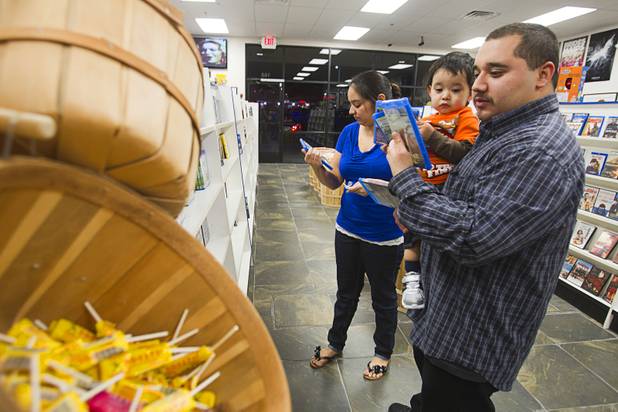 George Montes picks out movies with his son Aiden, 19-months, and his wife Rosemary at Movies & Candy, 10895 S. Eastern Ave., Thursday, January 17, 2013. Movie fan Trevor Layne opened the video shop last November when his house started overflowing with movies.