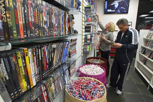 Katie Crispell and her father Ed stock shelves at Movies & Candy, 10895 S. Eastern Ave., Thursday, January 17, 2013. Movie fan Trevor Layne opened the video shop last November when his house started overflowing with movies.