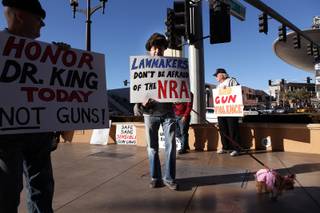 Alex Sayadi of Henderson holds up a sign during a demonstration in favor of President Obama's new gun regulations outside of the Palazzo on the Strip in Las Vegas on Saturday, January 19, 2013.