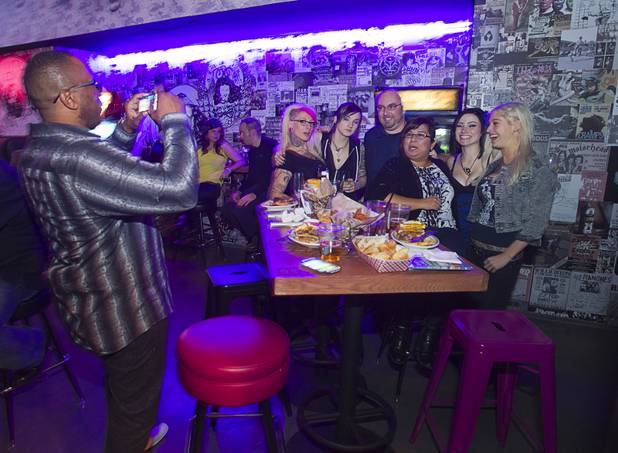 A "Black Hipster" friend takes a photo of Ruth and Jon Currie of Austin, Texas  as they pose with adult film actresses during the second annual Burning Angel porn brunch at the Rattlecan restaurant in the Venetian Sunday, Jan. 20, 2013. The brunch follows the AVN Adult Entertainment Expo which ended Saturday. About 40 guests joined adult film actresses as they downed signature "Pickleback" shots and rode a mechanical pickle, a drink concept that was inspired at the 2012 brunch.