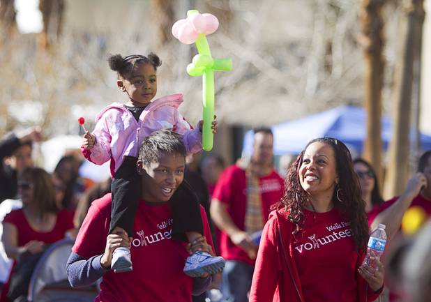 Harmony Green, 3, gets a ride on her aunt's shoulders as they march with Wells Fargo employees during the 31st annual Martin Luther King Jr. parade in downtown Las Vegas, Monday, Jan. 21, 2013. MGM Resorts International was the presenting sponsor for the event.