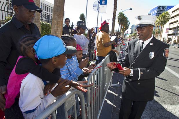 City of Las Vegas Fire Inspector Zach Collins passes out pencils during the 31st annual Martin Luther King Jr. parade in downtown Las Vegas, Monday, Jan. 21, 2013. MGM Resorts International was the presenting sponsor for the event.