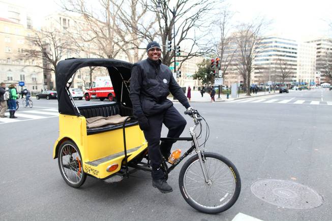 Kevin Bonner rides his pedicab at the corner of 15th and H Streets NW in Washington, D.C. after dropping off a customer on Inauguration Day, Monday, Jan. 21, 2013.