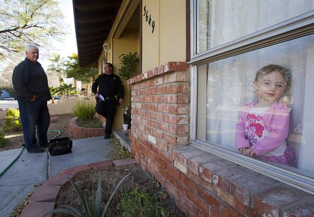 Joe Ingersoll, left, of All American Locksmiths, and Deputy Constable Patrick Geary wait outside a home during an eviction in the southwest part of the Las Vegas Valley Tuesday, Jan. 22, 2013. The residents of the home were not evicted after they reached a last minute arrangement with the landlord for extra time to move out.