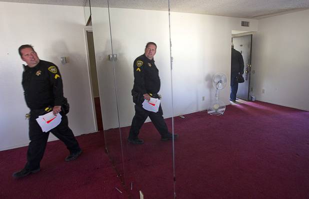 Deputy Constable Patrick Geary looks at a mirrored wall of an apartment during an eviction in the southwest part of the Las Vegas Valley Tuesday, Jan. 22, 2013. The tenants has already moved out.