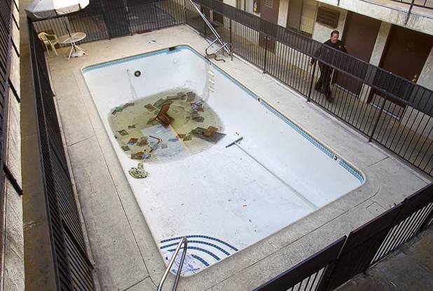 Deputy Constable Patrick Geary walks by a pool after posting a 24-hour eviction notice at an apartment complex near the Las Vegas Convention Center in the southwest part of the Las Vegas Valley Tuesday, Jan. 22, 2013. The complex has been purchased by the convention center and is slated for demolition. The residents have to leave and some have decided to stop paying their rent, Geary said.