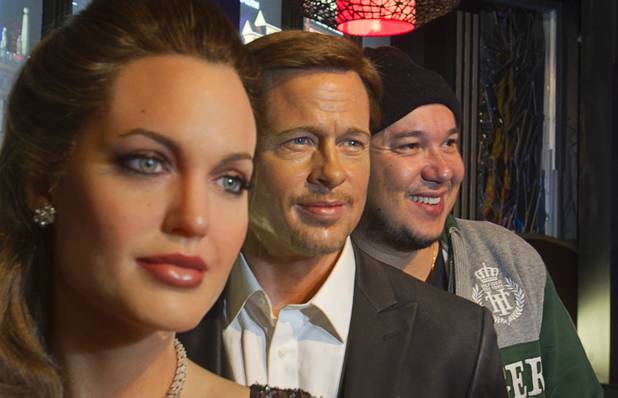 Rogerio Abbiti, right, of Brazil poses with wax figures of actors Angelina Jolie and Brad Pitt at Madame Tussauds Las Vegas wax museum in the Venetian Wednesday, Jan. 23, 2013. On Thursday, the venue will unveil a wax figure of actress Sandra Bullock.