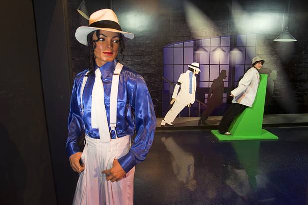 Morgane Valla, right, of France poses in an interactive exhibit featuring pop singer Michael Jackson at Madame Tussauds Las Vegas wax attraction in the Venetian Wednesday, Jan. 23, 2013. On Thursday, the venue will unveil a wax figure of actress Sandra Bullock.