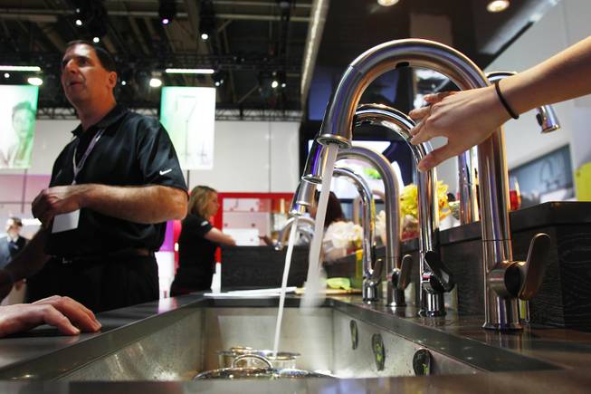 Motion sensitive kitchen faucets from Kohler are demonstrated at the NAHB International Builders' Show Wednesday, Jan. 23, 2013 at the Las Vegas Convention Center.