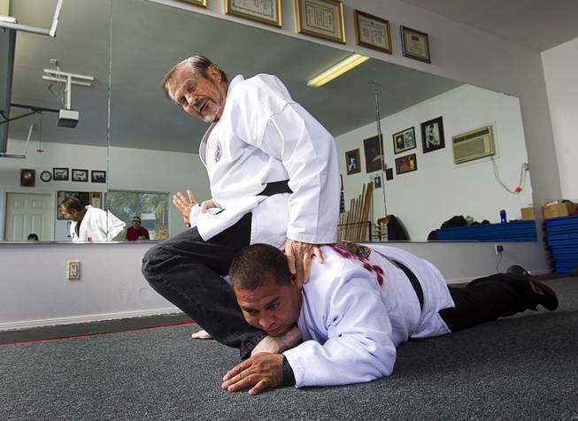 Karate master Dan Sawyer demonstrates a move on instructor Mauro Felix, a fifth degree black belt, during a class at his home Sunday, Jan. 27, 2013. Sawyer teaches in a garage behind his home that has been converted into a karate dojo.