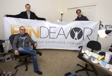 Company co-founders Tom Ellinson, left, and Dean Curtis pose with content manager Darren Flores, seated, at the Fandeavor offices in the Ogden in downtown Las Vegas Monday, Jan. 28, 2013. Fandeavor is a sports marketing group that sells special game-day packages to fans.