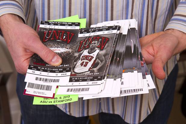 Company co-founder Tom Ellinson holds tickets to upcoming sporting events at the Fandeavor offices in the Ogden in downtown Las Vegas Monday, Jan. 28, 2013. Fandeavor is a sports marketing group that sells special game-day packages to fans.